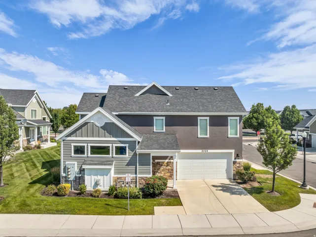 Contemporary-style residence featuring a two-car garage, stone accents, and varied siding textures