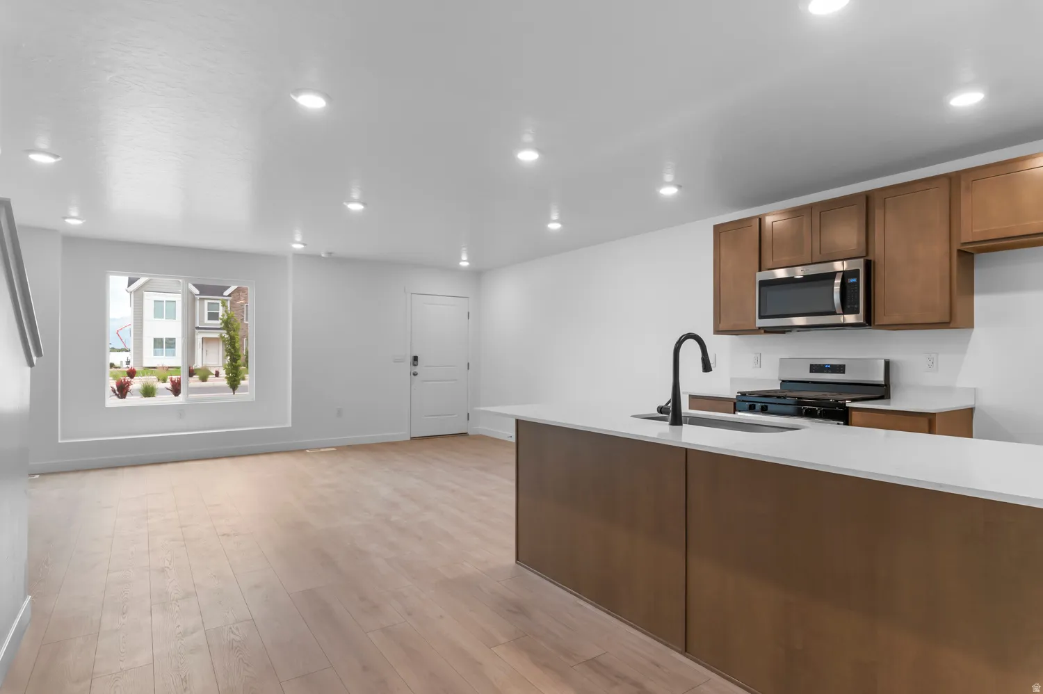 Modern kitchen island with a stone-finish countertop, matte black faucet, and undermount sink