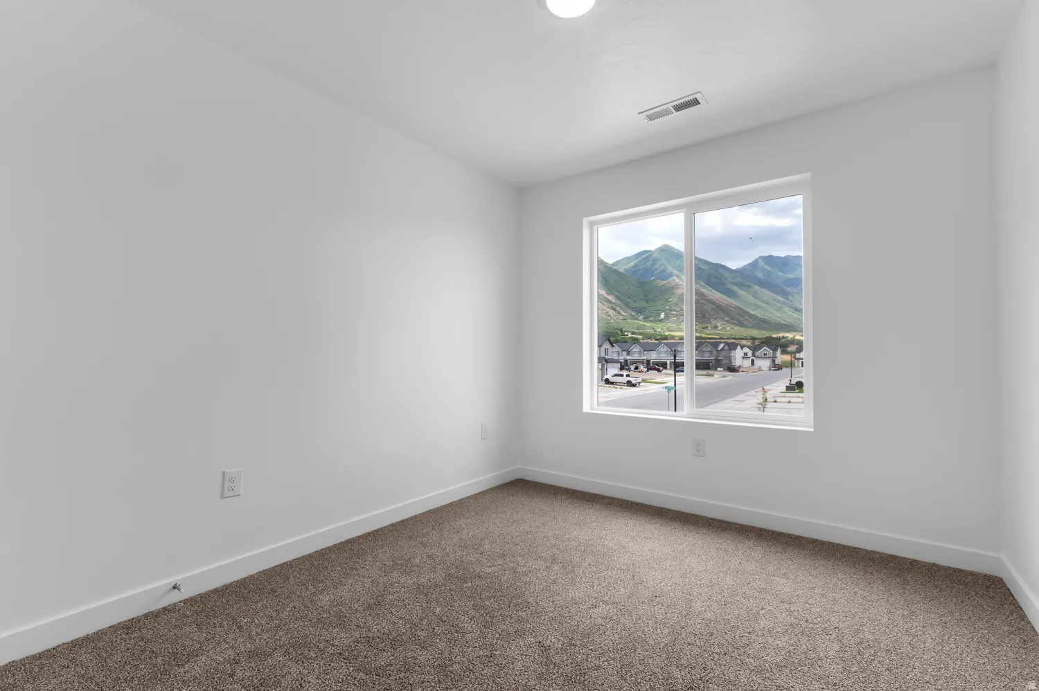 Room with neutral-toned carpet, white painted walls, and white baseboards