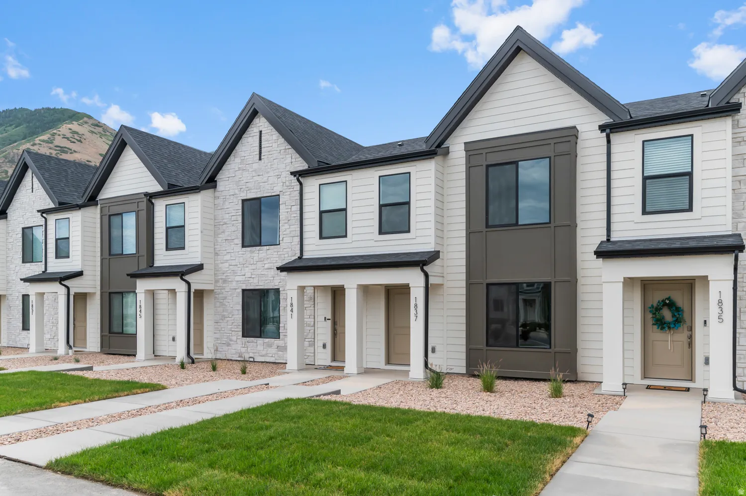 Modern townhome with multi-textured facade featuring stone veneer and horizontal siding