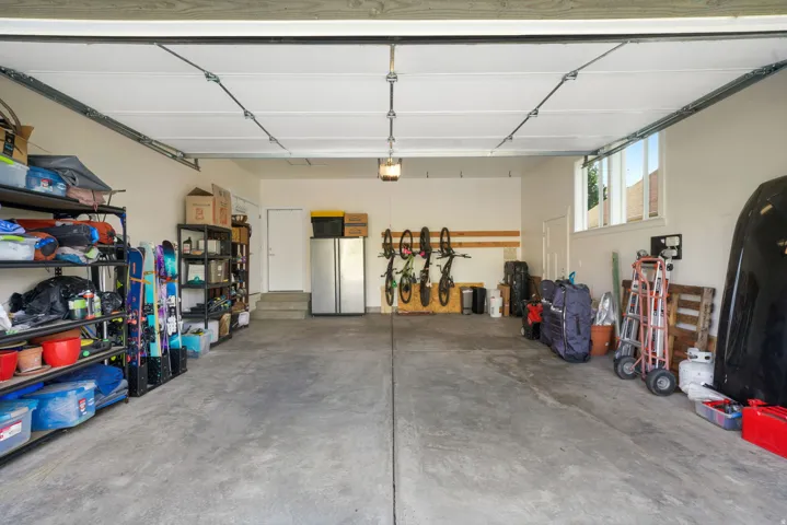 Spacious garage featuring concrete flooring and a white overhead garage door