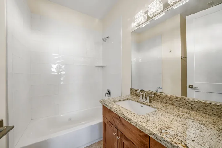 Spa-inspired master bathroom featuring a granite countertop with an undermount sink, oil-rubbed bronze faucet fixtures, and rich wood cabinetry