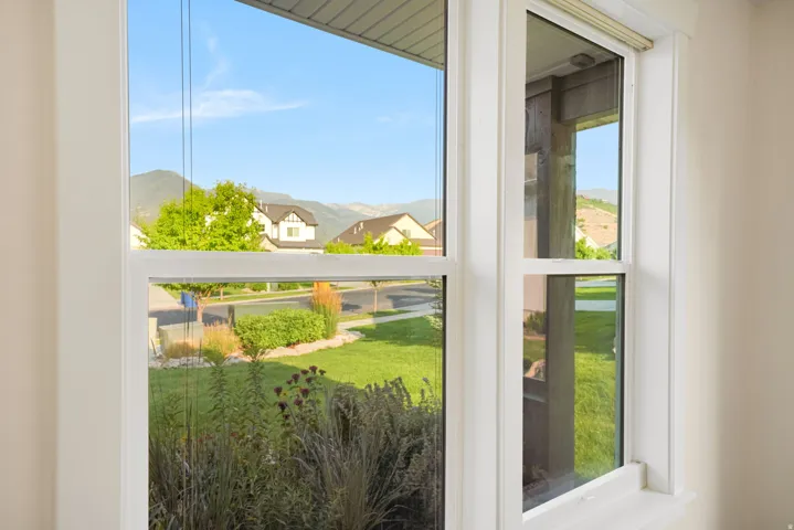 White-framed window offering a landscape vista of distant mountains and a residential street