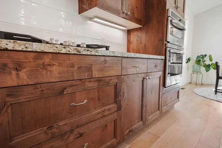 Wood-finish cabinetry paired with light-toned countertops and a white subway tile backsplash