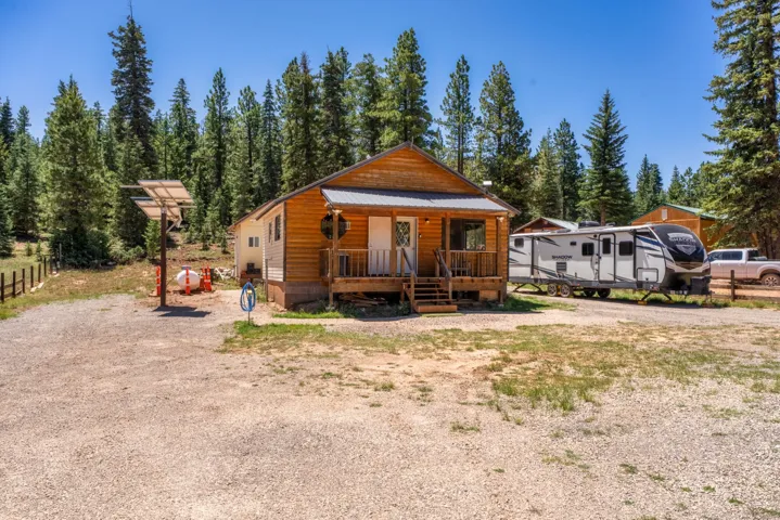 Wood-sided cabin featuring a covered front porch and metal roof