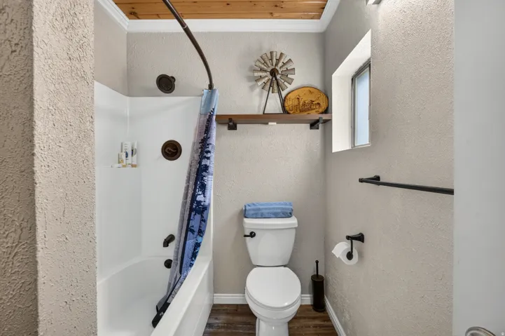 Bathroom featuring a white tub and shower combination with dark-finished fixtures
