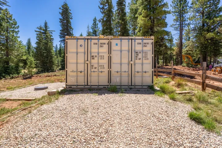 Pair of beige storage containers on a gravel pad
