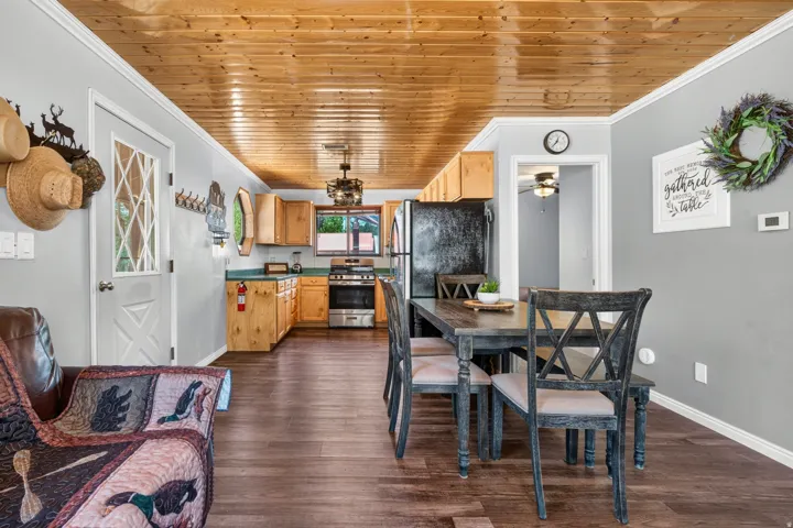 Open concept living area featuring wood-finish flooring and a natural wood plank ceiling