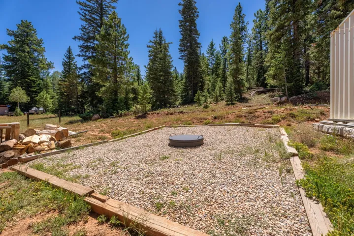Gravel patio with a built-in fire pit, bordered by natural wood planks