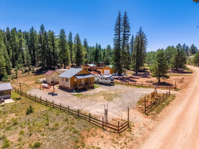 Wood-sided cabin featuring a covered porch with natural wood railing