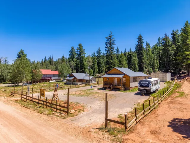 Wood-sided cabin featuring an inviting front porch and a gravel driveway