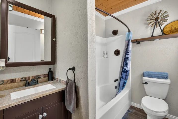 Bathroom featuring a vanity with a rectangular undermount sink, a countertop with an integrated backsplash, and a framed mirror