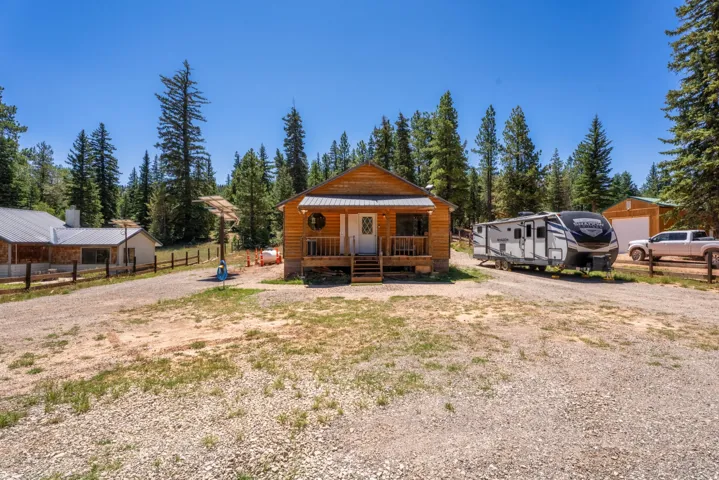 Wood-sided cabin with a covered front porch and multi-pane front door