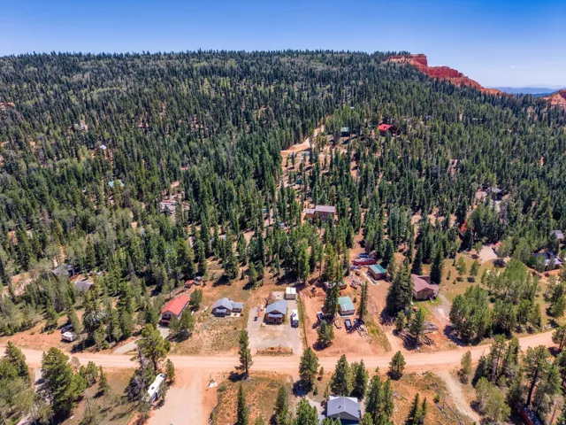 Sprawling wooded landscape featuring dense evergreen forests and rugged red rock formations