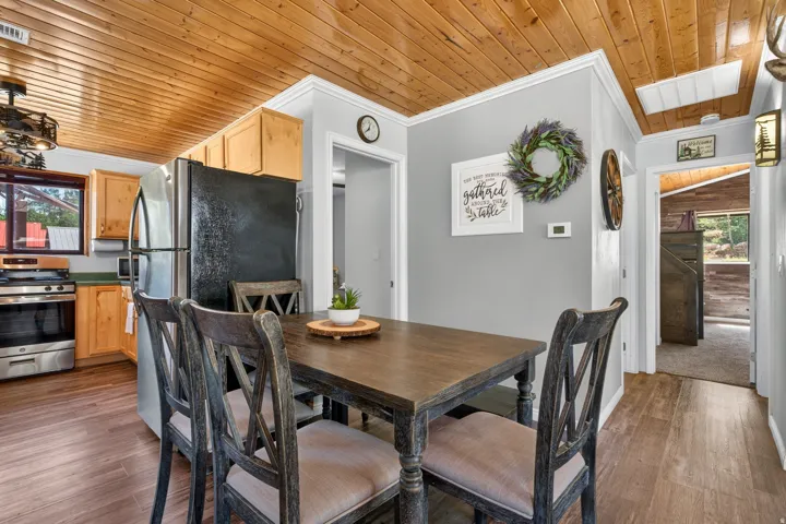 Dining area featuring wood-finish flooring and a natural wood plank ceiling