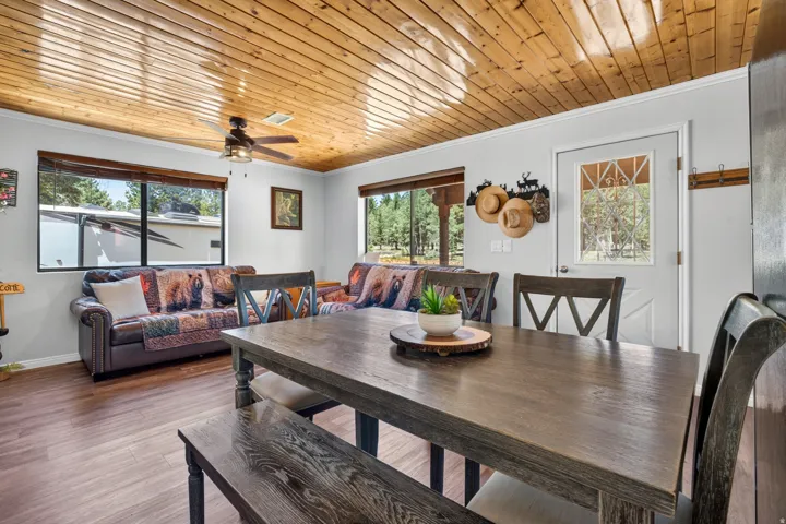 Open concept living area with wood-finish flooring and a natural wood plank ceiling