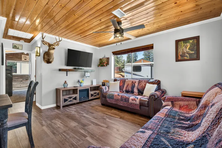 Living area featuring a natural wood-finish plank ceiling and coordinating wood-finish flooring