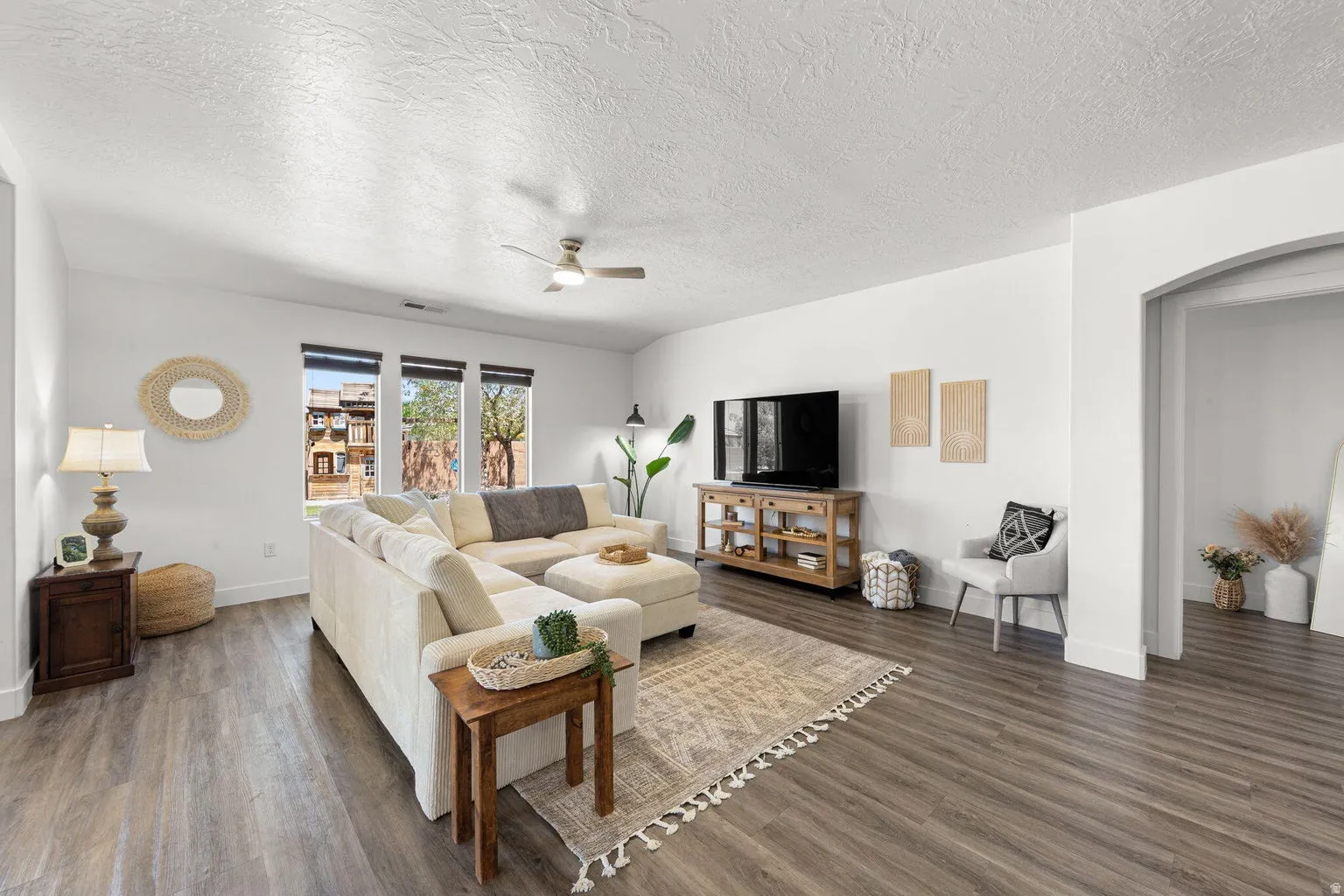 Spacious living area featuring wood-finish flooring, recessed lighting, and a ceiling fan