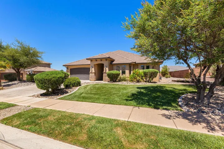 Single-story residence featuring a stucco exterior with a tile roof, an integrated two-car garage, and a covered entry