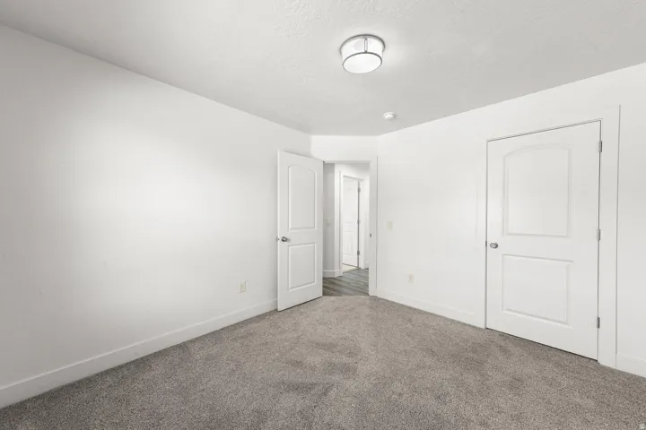 Carpeted interior space featuring white walls and a contemporary flush mount ceiling light