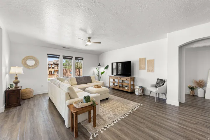 Spacious living area featuring wood-finish flooring, recessed lighting, and a ceiling fan