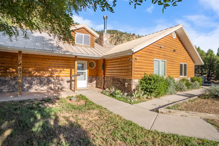 Charming log-constructed residence featuring warm wood-finish siding, metal roofing, and a covered entry