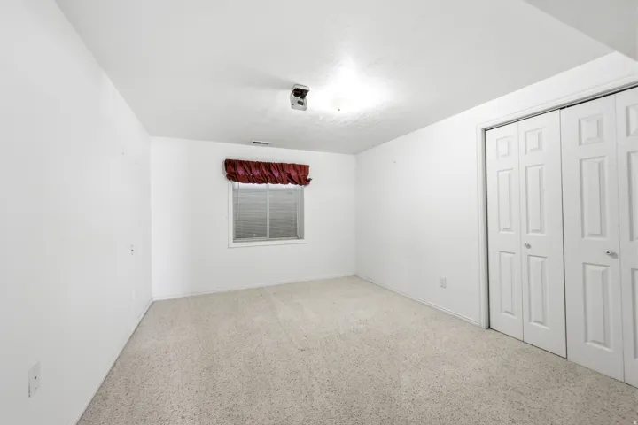 Bright interior space featuring light-toned carpet flooring and white painted walls