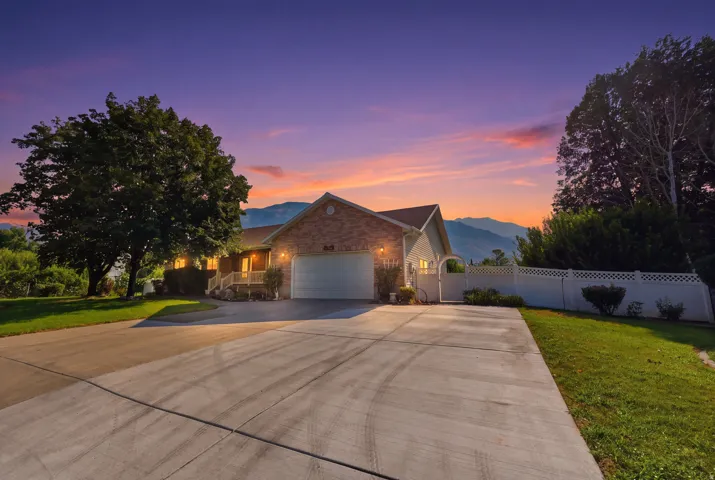 Brick and siding exterior featuring an attached garage and a concrete driveway