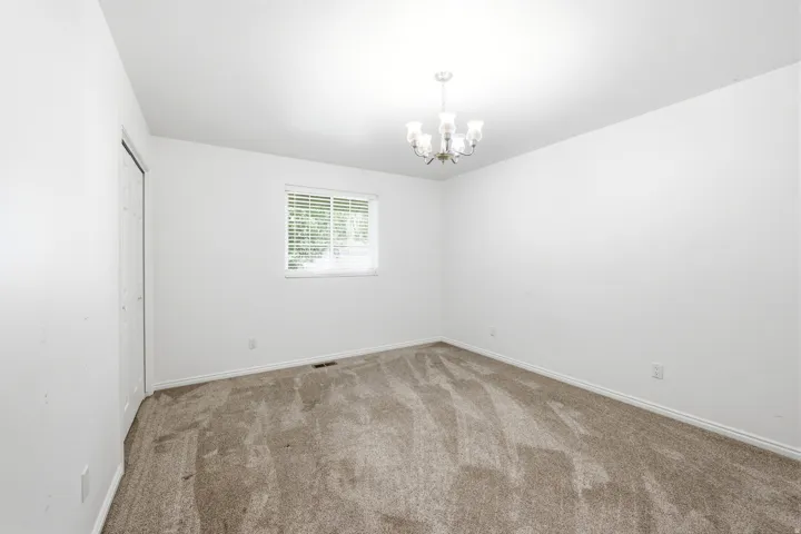 Spacious room featuring neutral carpeting and white walls