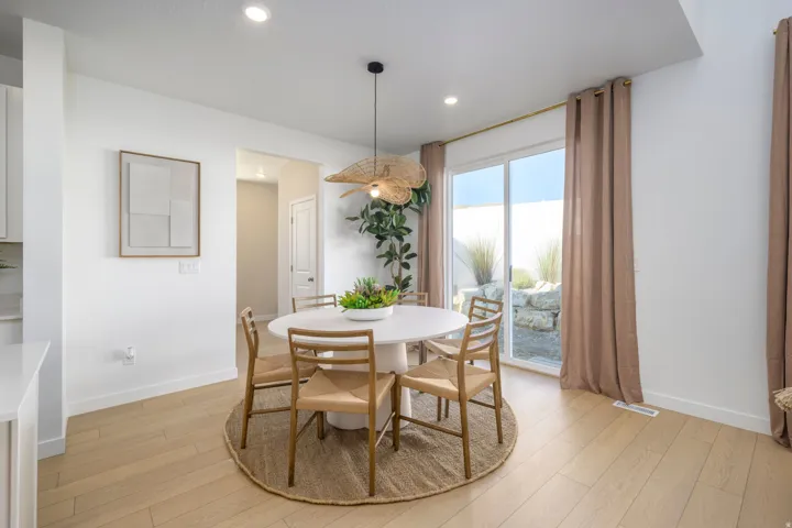 Dining area featuring light wood-finish flooring, recessed lighting, and a contemporary pendant light fixture