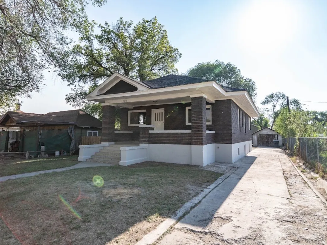 Brick exterior residence featuring a covered front porch, concrete entry steps, and an extended concrete driveway