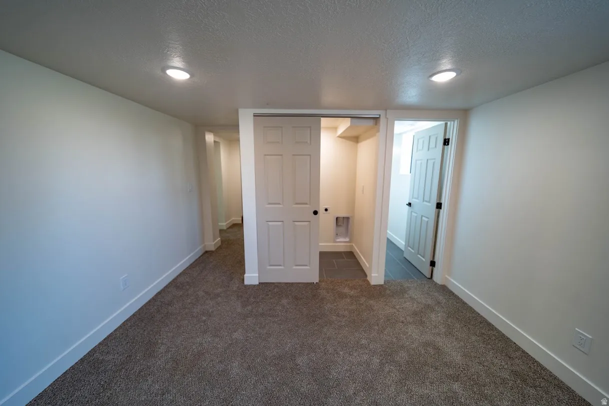 Carpeted room featuring recessed lighting, a sliding closet door, and a tiled utility area