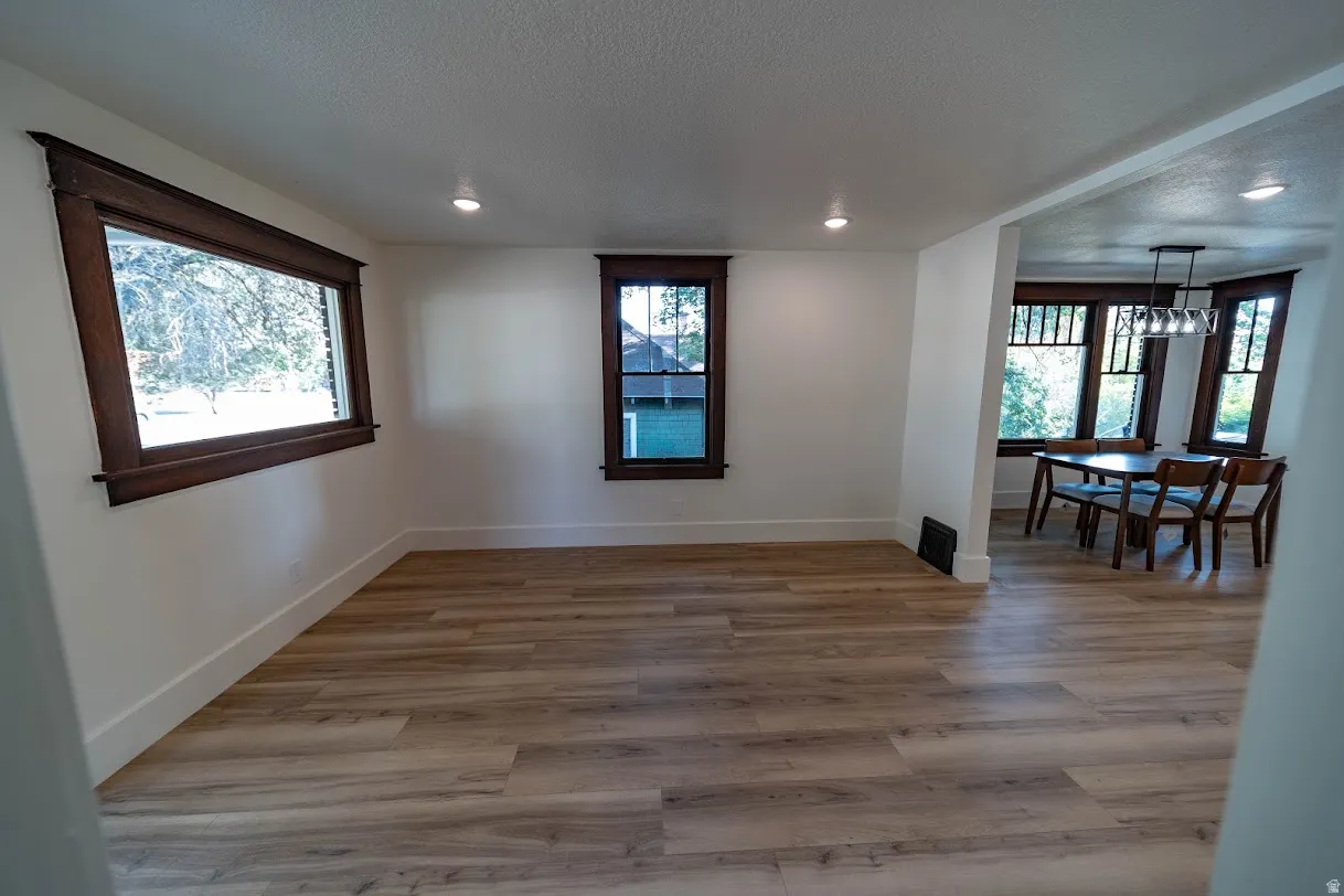 Open-concept living space featuring light wood-finish flooring, white walls, and recessed lighting