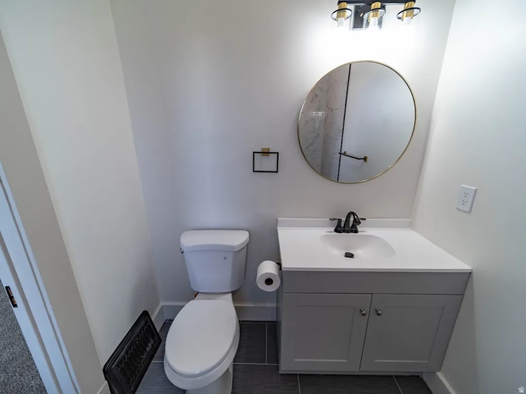 Bathroom featuring a contemporary vanity with a white countertop, undermount sink, and matte black faucet