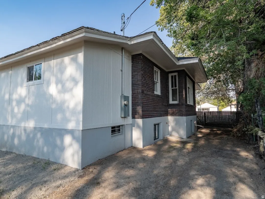 Property exterior featuring a combination of brick and siding, a two-tone foundation, and a gravel driveway