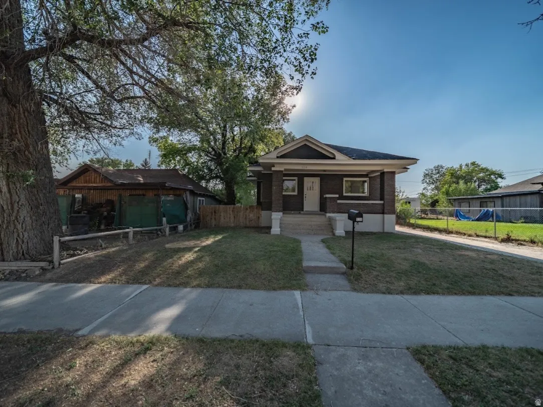 Craftsman-style home with a brick facade and a covered front porch featuring white pillars