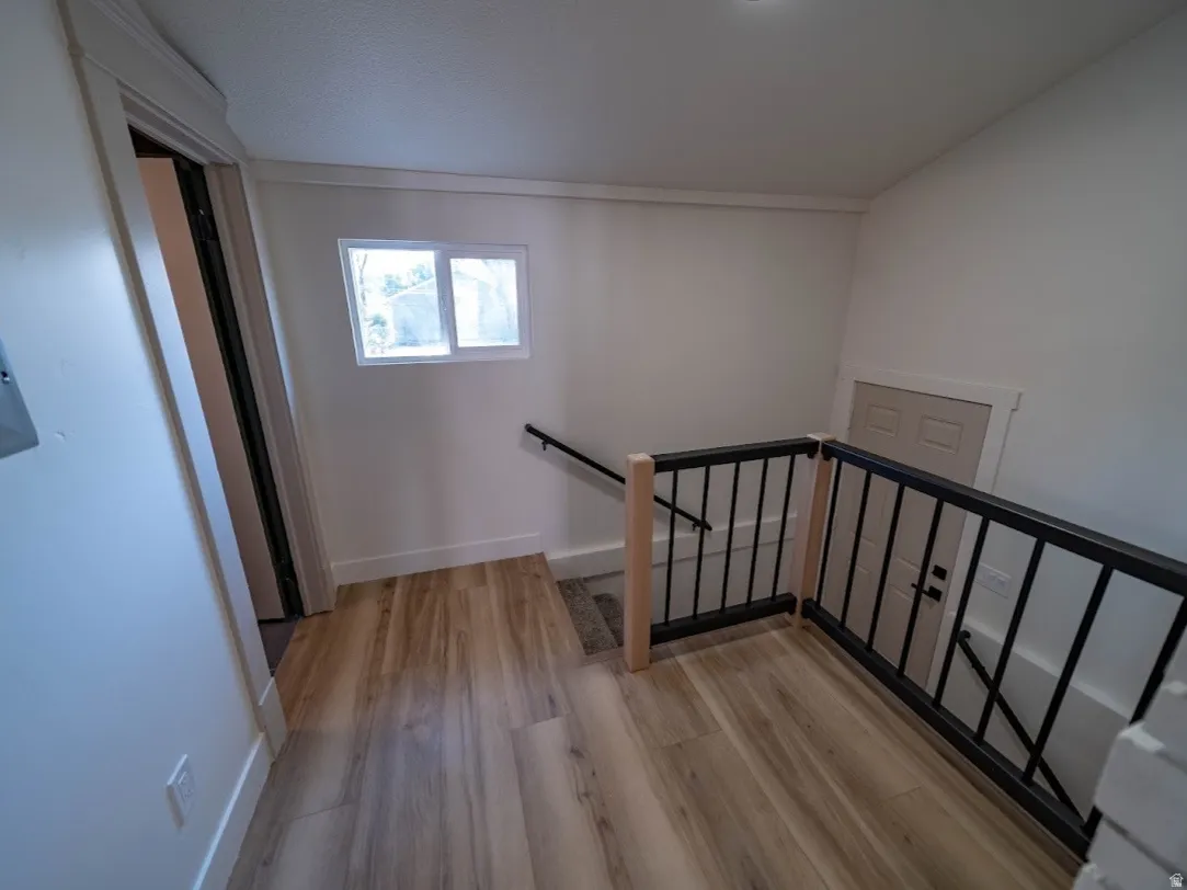 Upper landing with wood-finish flooring, white walls, and a recessed ceiling light. Half bath is located by the stairs.