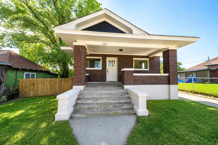 Brick-clad facade with a covered front porch and concrete steps