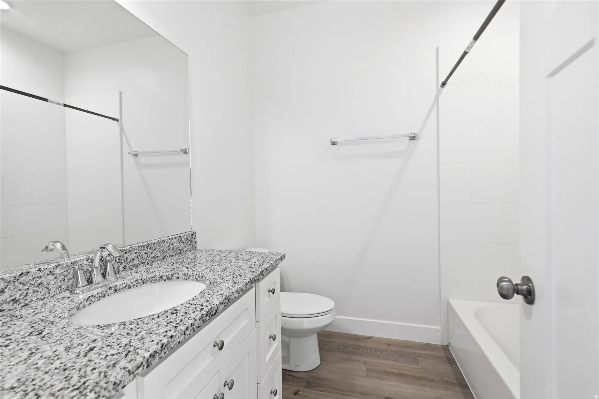 Bathroom featuring a vanity with a white cabinet base, speckled countertop, and undermount sink
