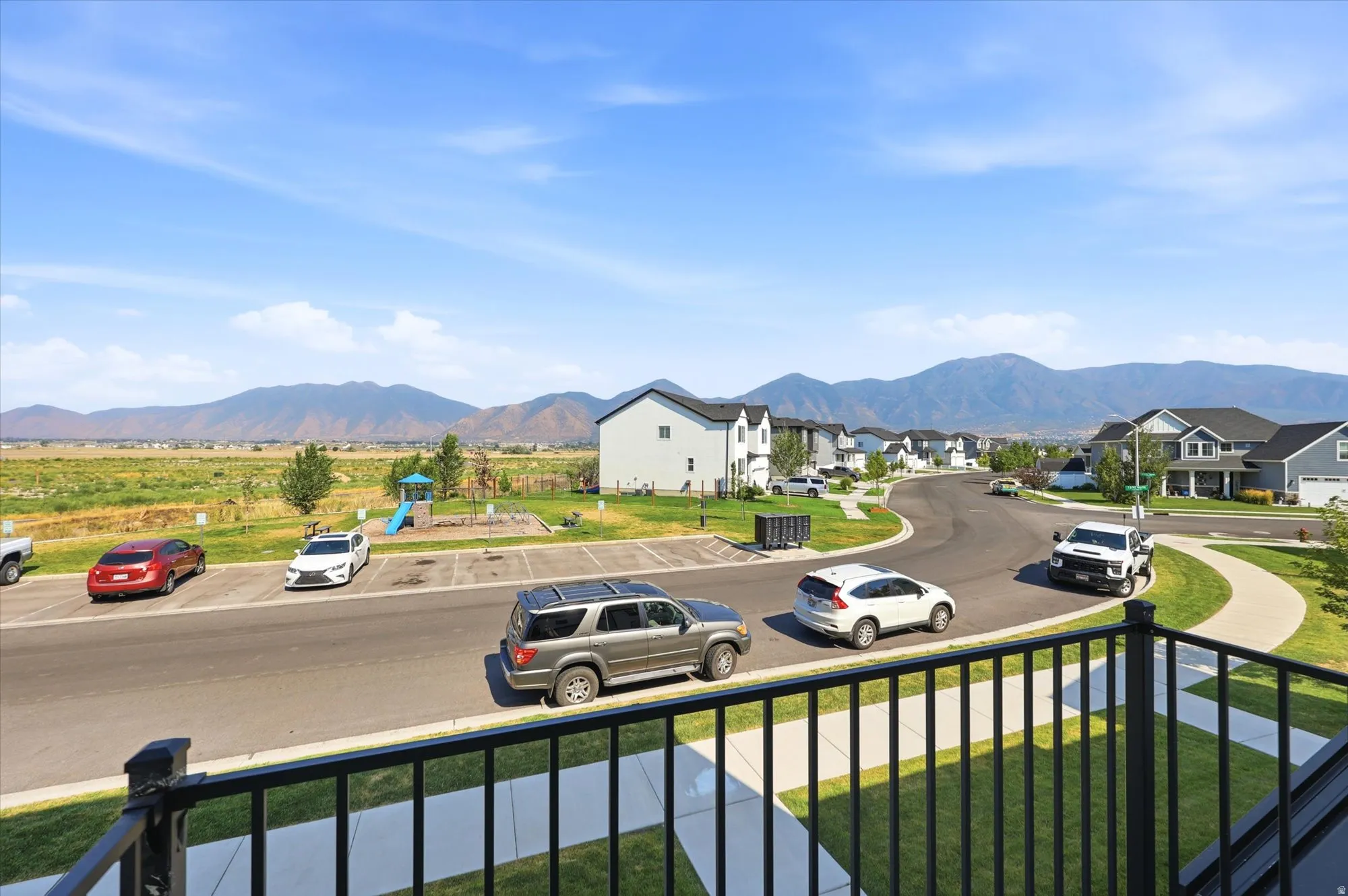Neighborhood street with mountain scenery, offering residential homes and open fields