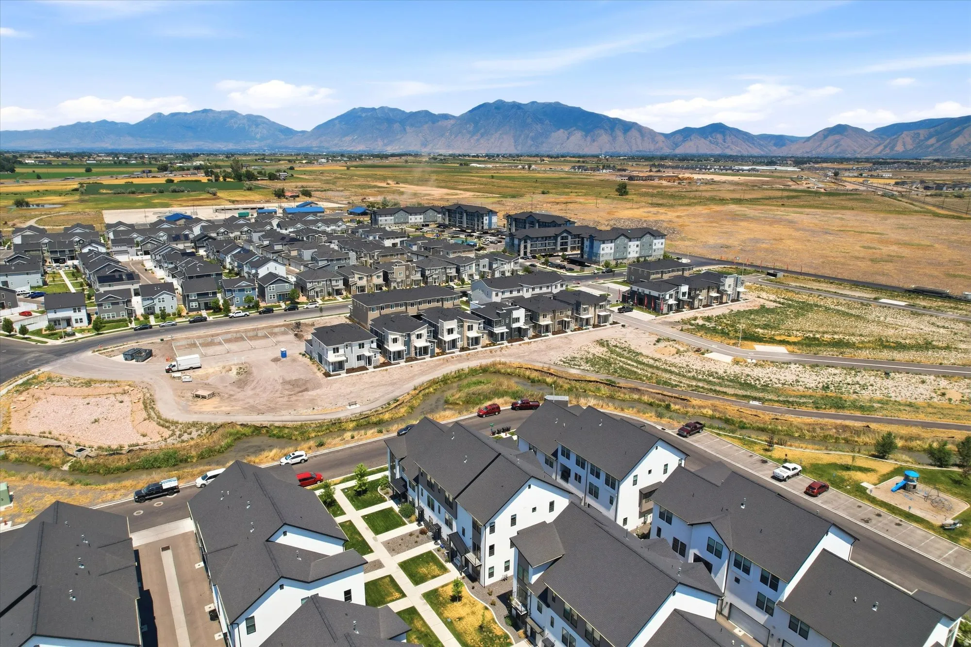 Aerial perspective showcasing a developing residential area with modern multi-story buildings and single-family homes