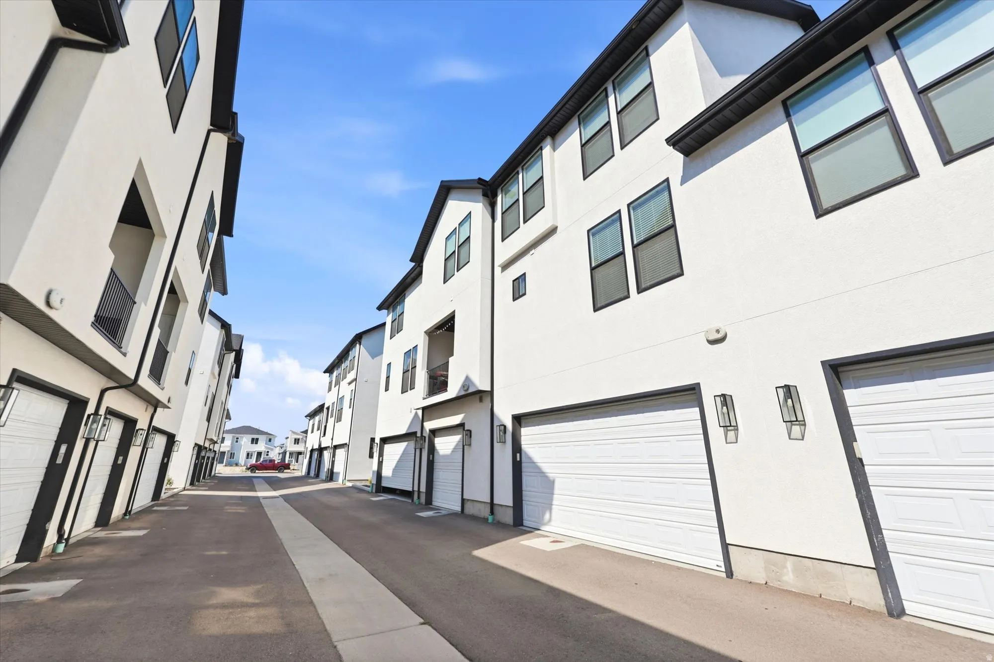 Contemporary multi-story residences featuring white stucco exteriors and dark trim accents