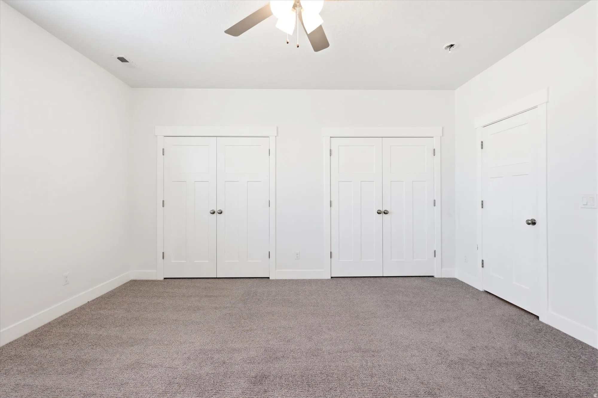 Room featuring light gray carpeting and white walls