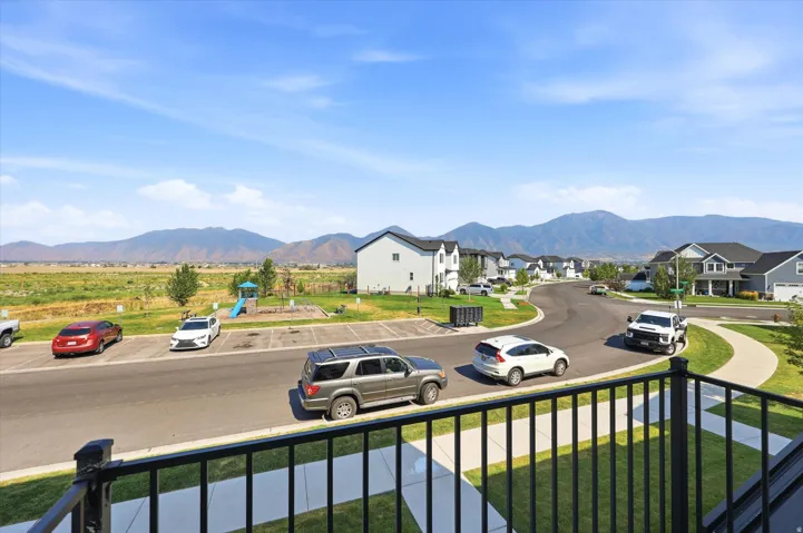 Neighborhood street with mountain scenery, offering residential homes and open fields