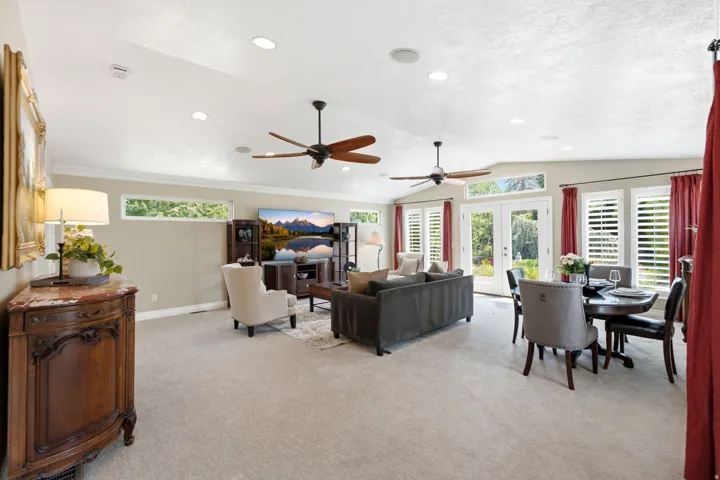 Spacious interior with vaulted ceilings, recessed lighting, and multiple ceiling fans - family room with formal dining