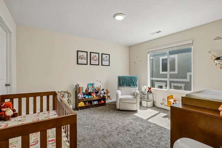 Carpeted room with a large window, neutral wall paint, white trim, and a flush-mount ceiling light
