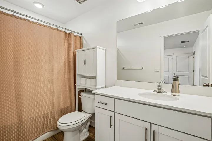 Bathroom featuring a vanity with an integrated sink, white countertop, and white cabinetry with brushed nickel hardware