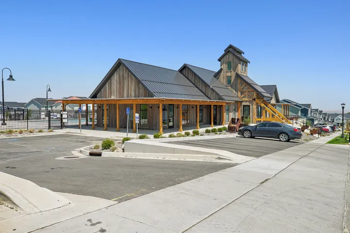 Modern commercial or mixed-use building featuring a striking yellow and black exterior with pitched rooflines and multiple gabled sections
