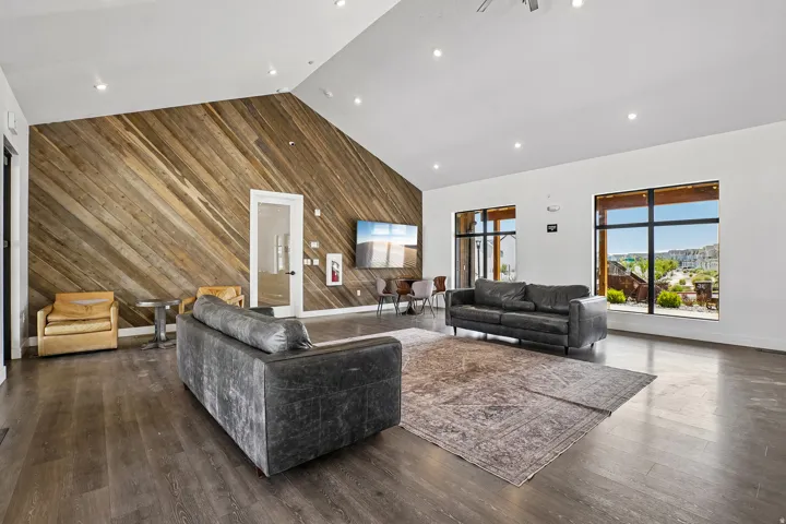 Spacious interior featuring a vaulted ceiling and an accent wall with diagonal wood paneling