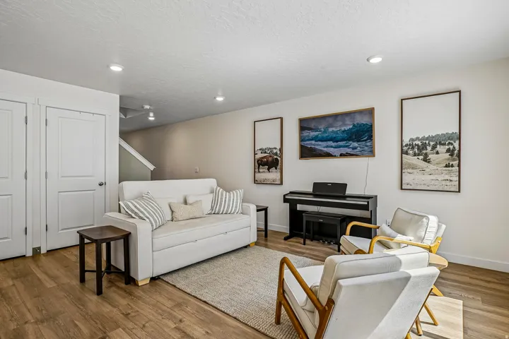 Open-concept living area featuring wood-finish flooring, recessed lighting, and a light color palette